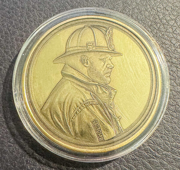 Embossed Challenge Coin with the side image of a firefighter.